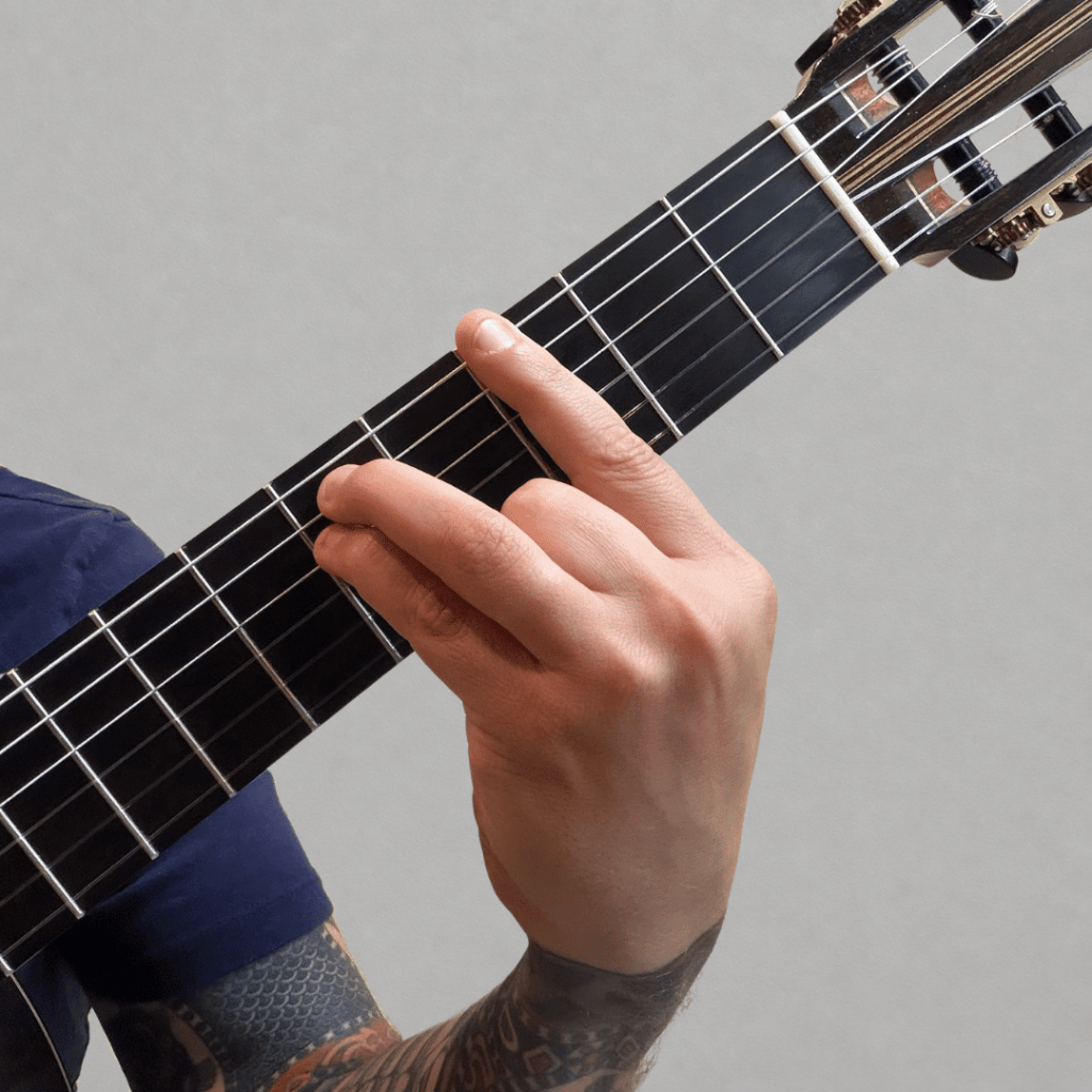 hand playing G Minor chord on classical guitar